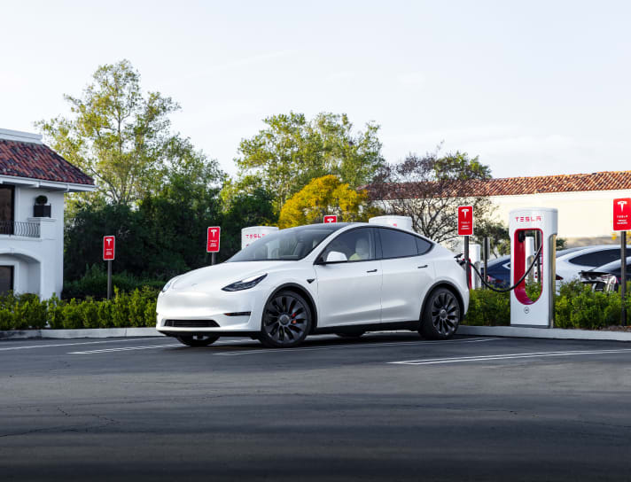 White Model Y charging at a Supercharger