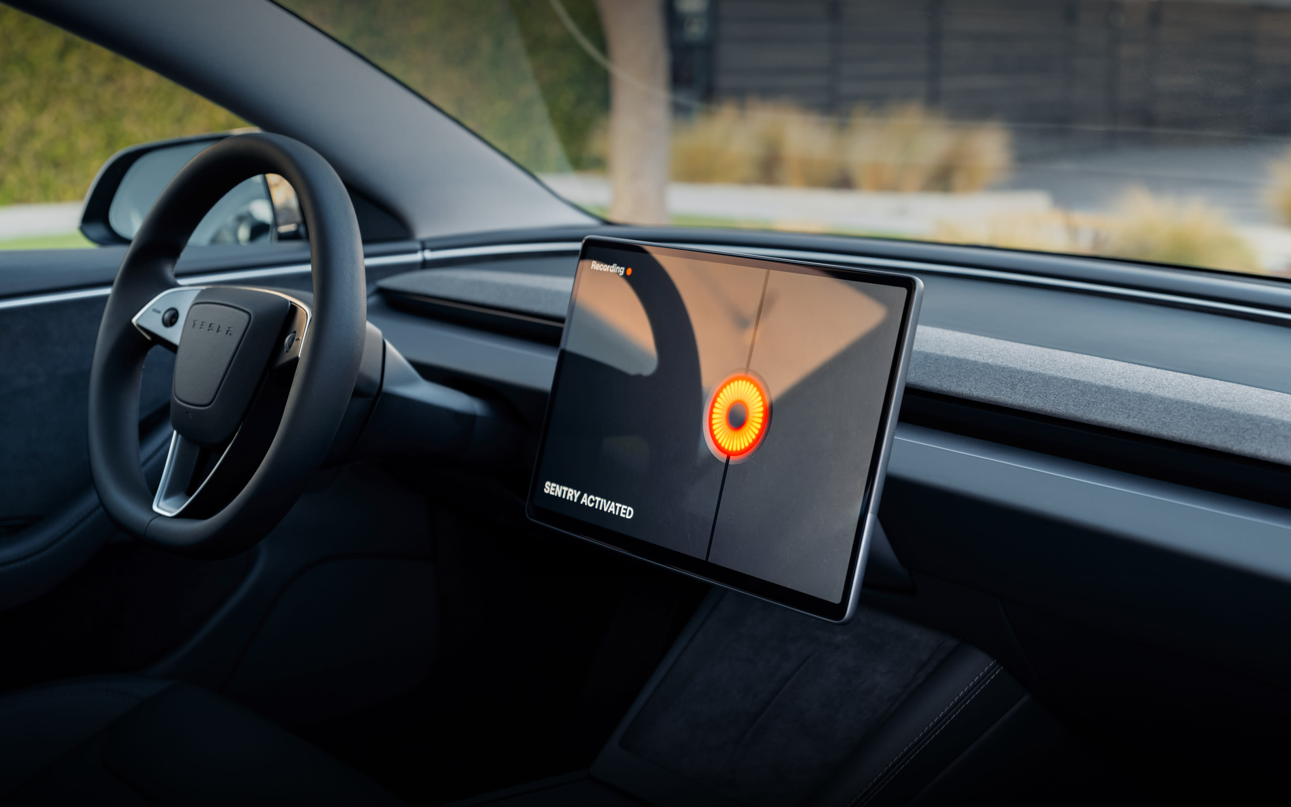 Center touchscreen displaying 'Sentry Activated' and recording.