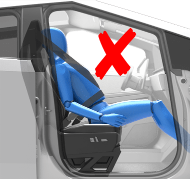 Person sitting in car seat incorrectly with hips at the front of the seat cushion